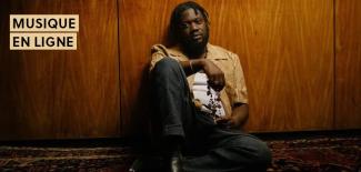 michael kiwanuka assis adossé à un mur